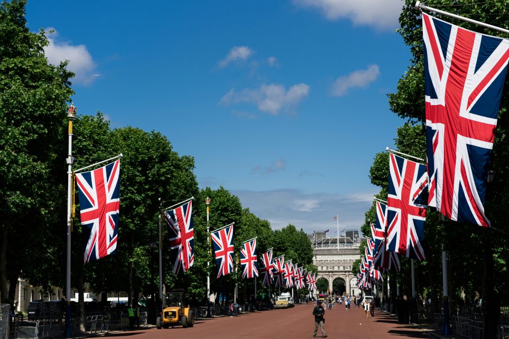 A picturesque street decorated with British flags, complemented by a building standing prominently in the background.