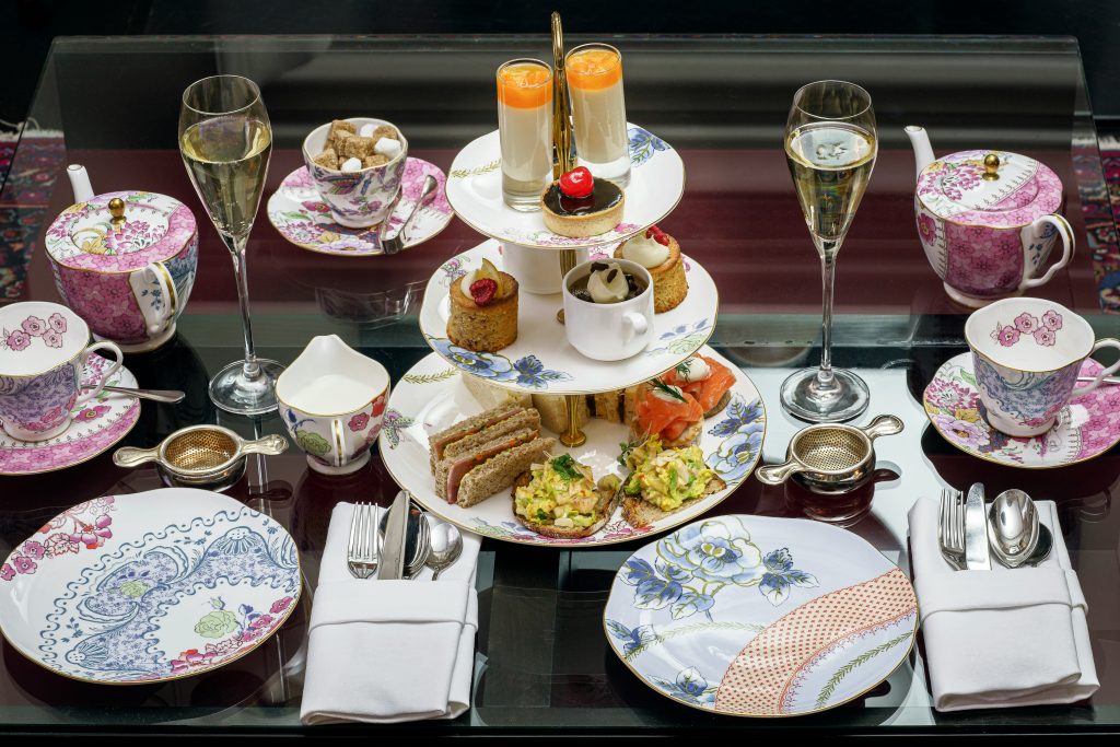 A charming afternoon tea scene showcasing an array of sweets, scones, and tea served on a decorative table.