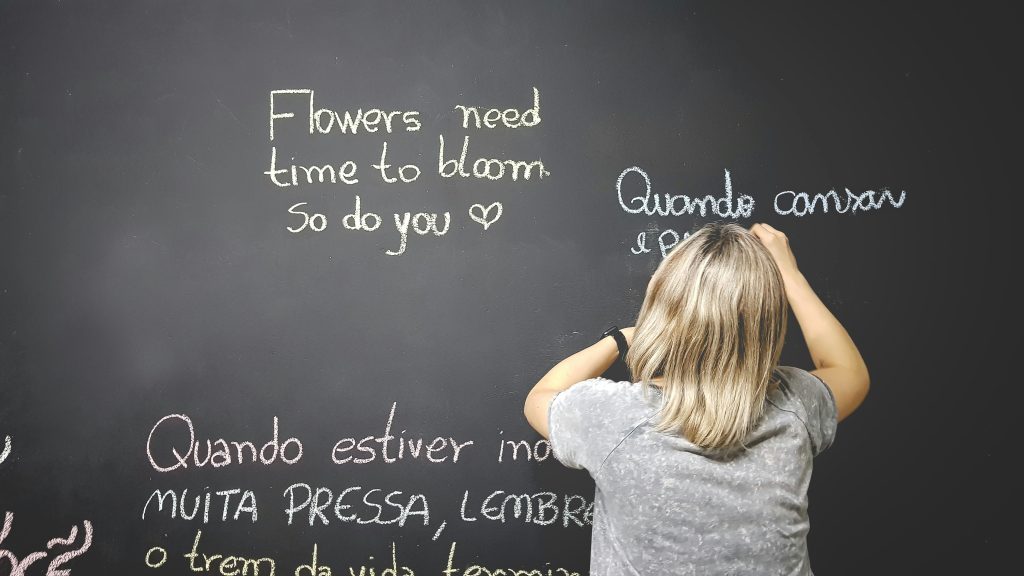 Female teacher writing on a chalkboard.