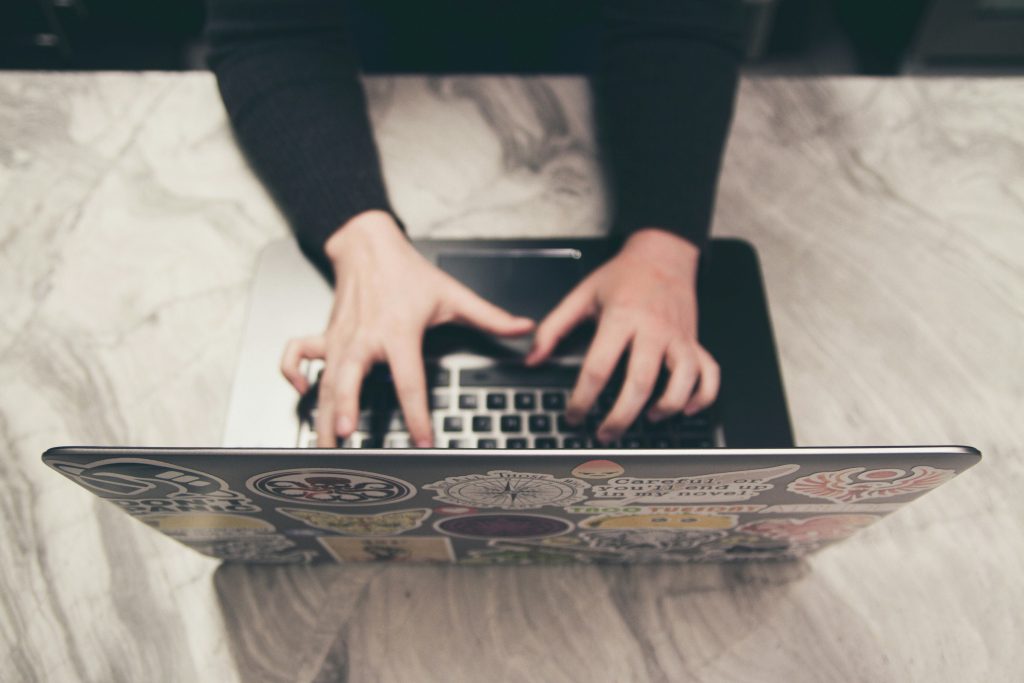 A person typing on a computer keyboard seen from above