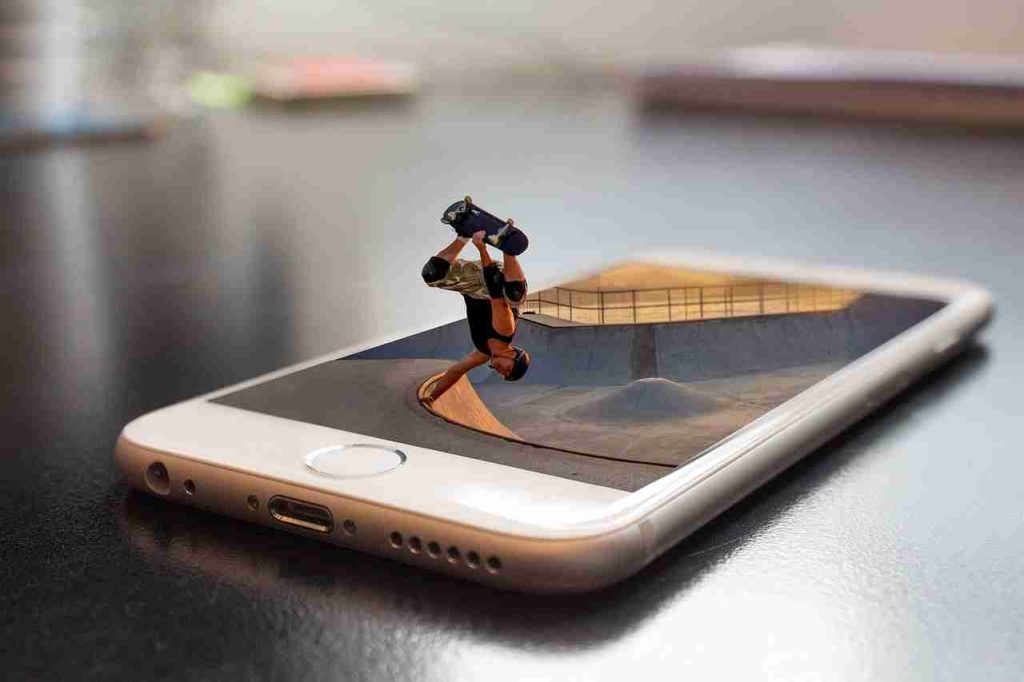 A little man on a skateboard emerging from an iPhone left on a table