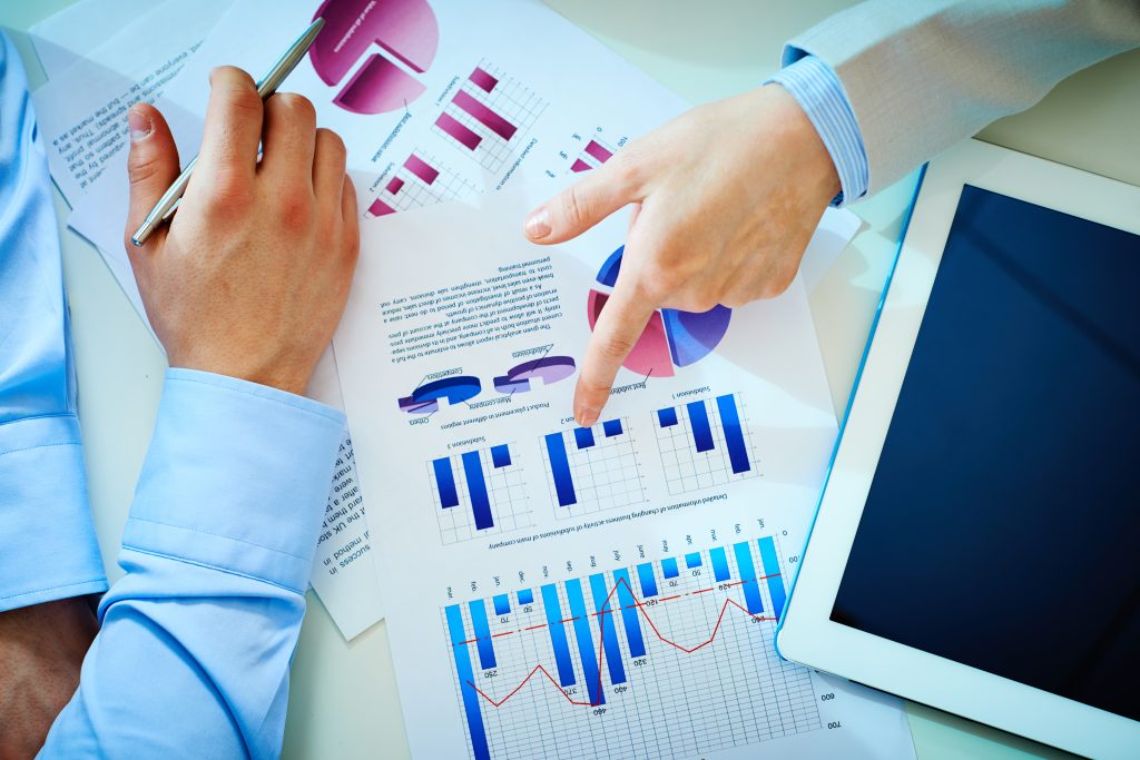 Employees' hands over bar chart graphics.