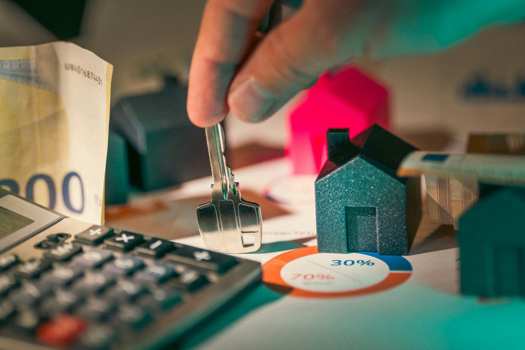 A close up on the key, banknote, calculator and small houses