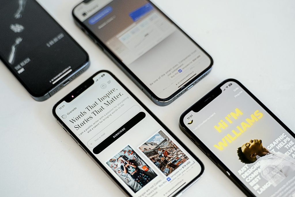 four iphones on a table showcasing different articles