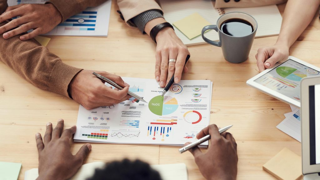 hands pointing at a business chart