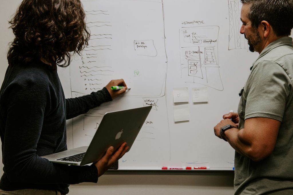 People talking and writing on a whiteboard